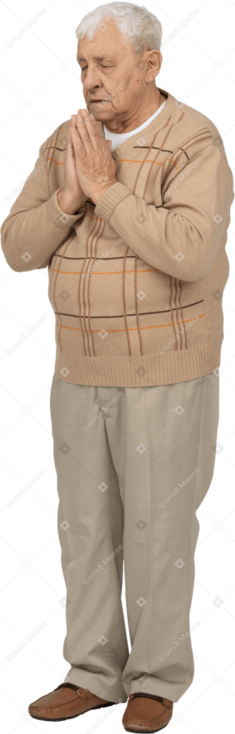 カジュアルな服装の老人の正面図は、祈りのジェスチャーで手をつないでいます