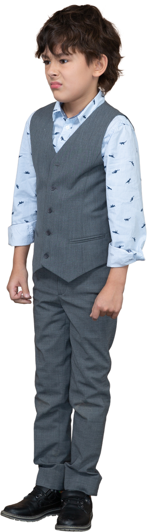Vista frontal de um menino triste em um terno cinza parado