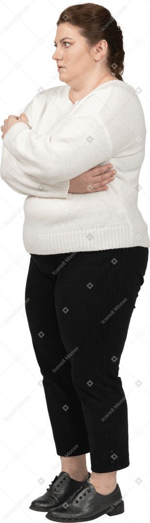 Femme de taille plus dans des vêtements décontractés debout de profil avec les bras croisés