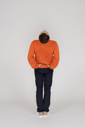 Young man in orange sweatshirt posing