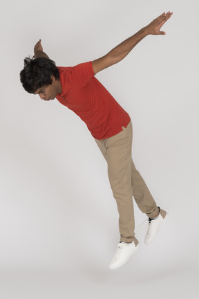 Young man falling down with arms spread