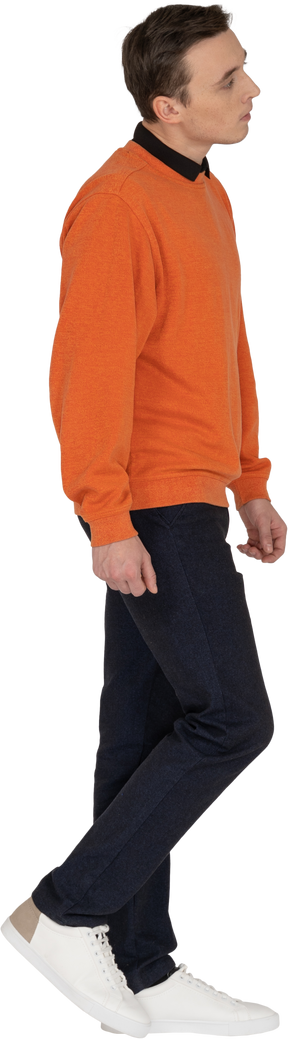 Young man in orange sweatshirt walking