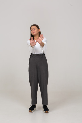 Vista frontal de uma jovem relutante com roupas de escritório estendendo o braço
