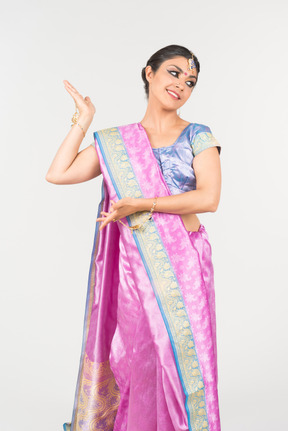 Young indian woman in purple sari standing with hands folded