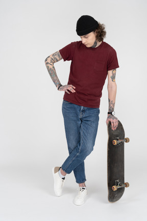 Ein teenager, der mit seinem skateboard steht