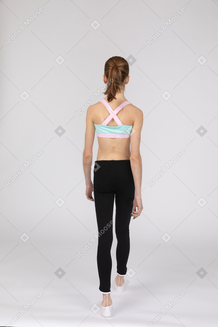 Vista posteriore di una ragazza adolescente in abiti sportivi a piedi