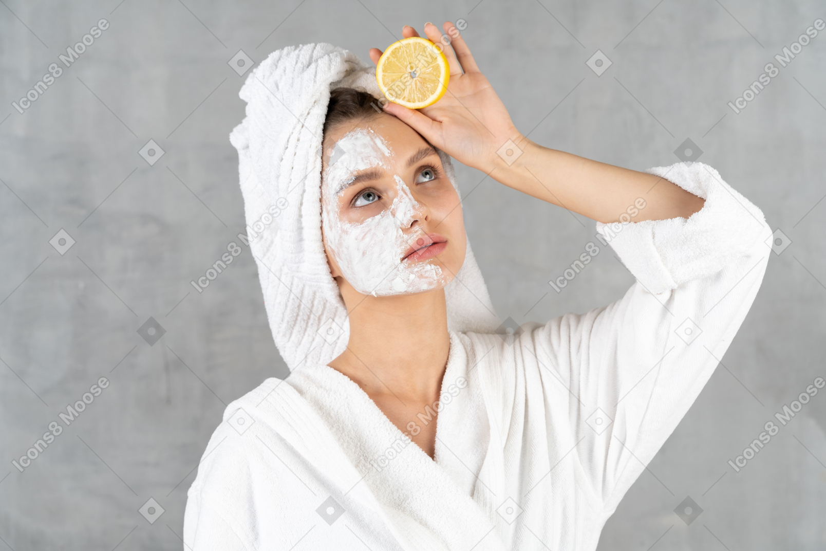 Close-up of a woman in bathrobe with a lemon in hand