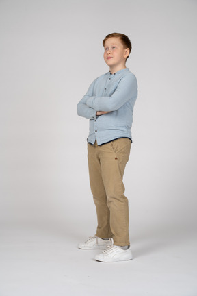 Boy posing with crossed arms and looking up