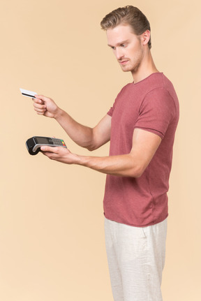 Young guy using a payment terminal