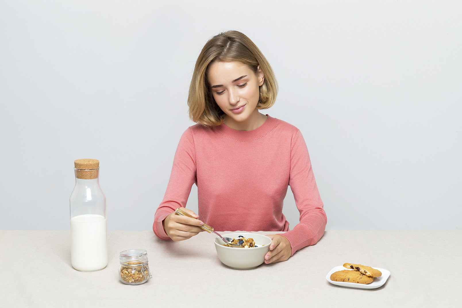 Young girl eating cereal with milk