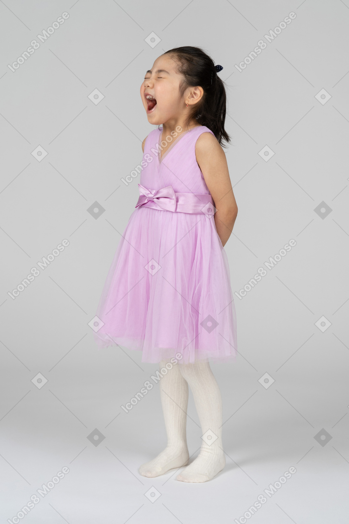 Three-quarter view of a beautifully dressed girl yawning