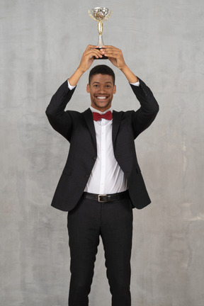 Man holding up award in celebration of his win