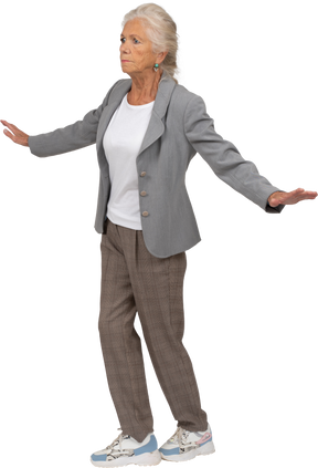 Side view of an old lady in suit standing with outstretched arms
