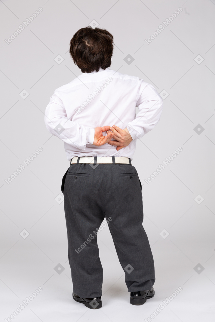 Rear view of businessman folding hands behind back