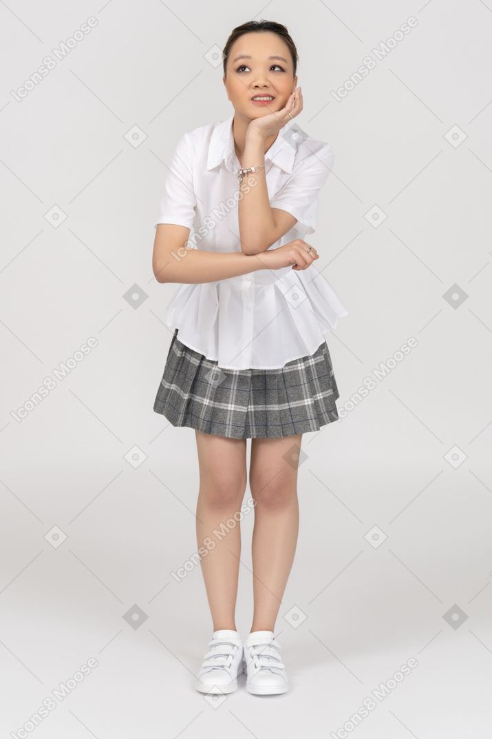 A cheerful asian girl leaning her head on her hand