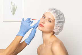 Young woman getting filler injection