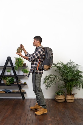 Side view of a backpacker holding a flask