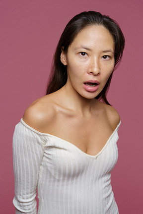 Вид в три четверти шокированной женщины средних лет, смотрящей в камеру с открытым ртом