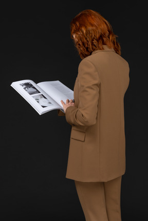 Back view of a woman in a suit reading