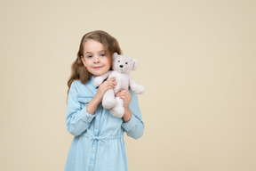 Niña linda sosteniendo un oso de peluche