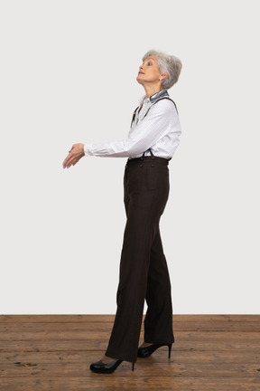 Side view of an impatient old lady outstretching her hand