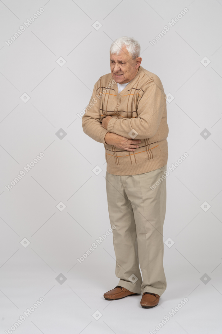Front view of an old man suffering from stomachache