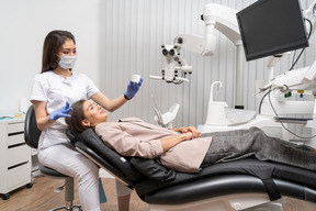 Longitud total de una dentista y su paciente mirando modelo de dientes