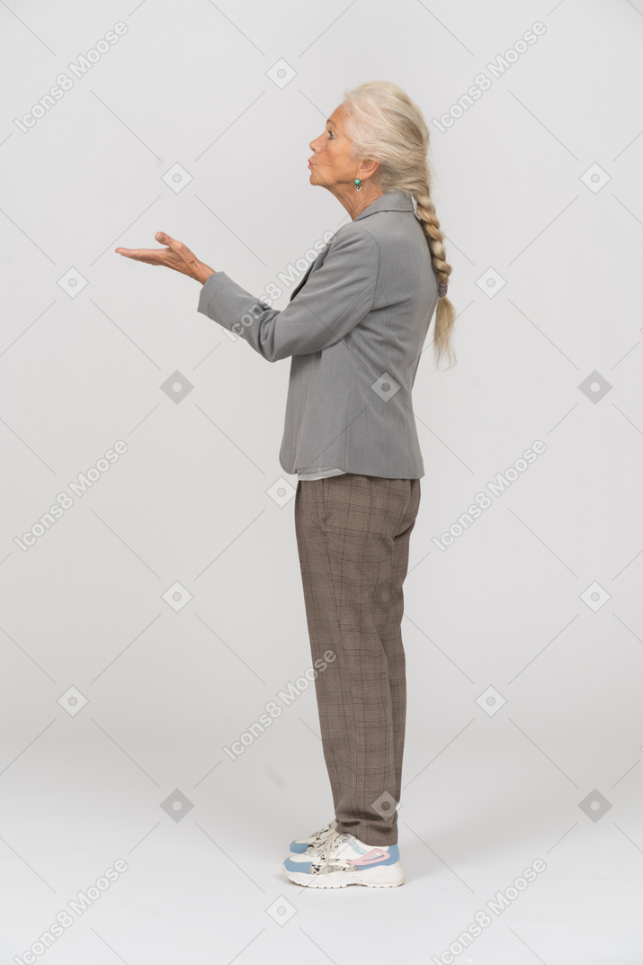 Side view of an old woman in suit blowing a kiss