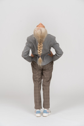 Rear view of an old lady in suit doing exercices