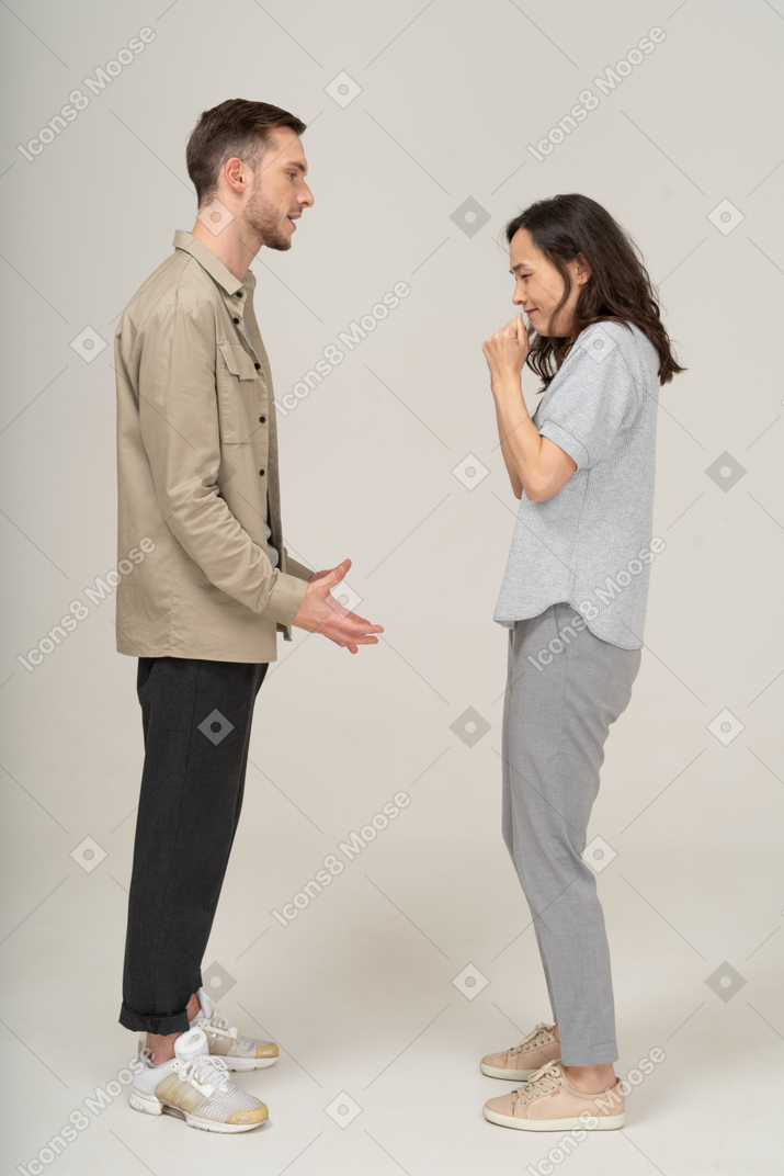 Vista lateral do jovem casal falando um com o outro