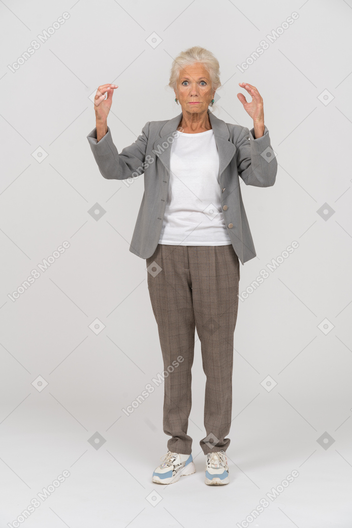 Front view of an old lady in suit standing with raised arms