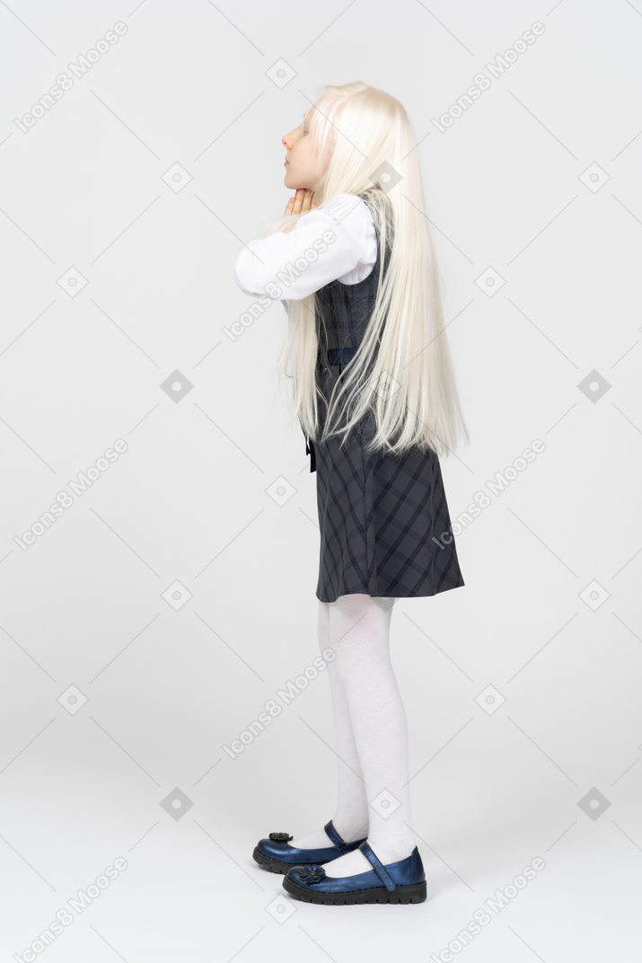 Side view of a schoolgirl praying