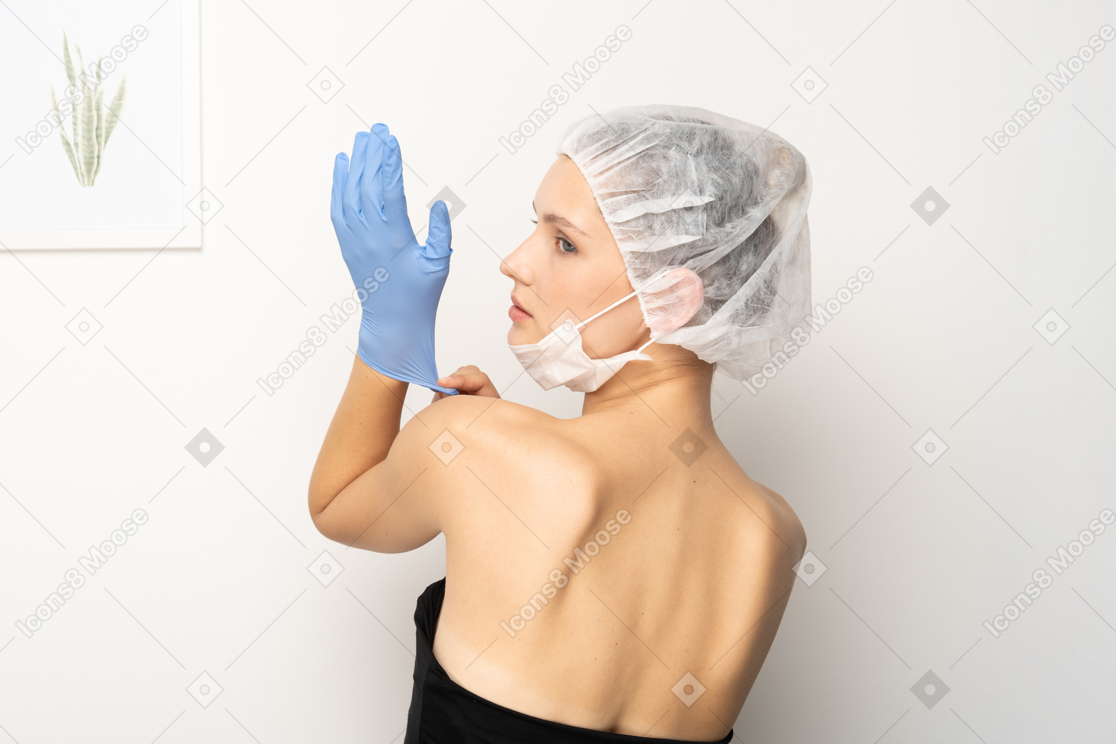 Young woman putting on medical gloves