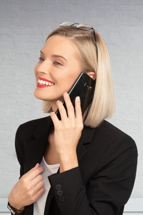 A woman in a business suit talking on a cell phone