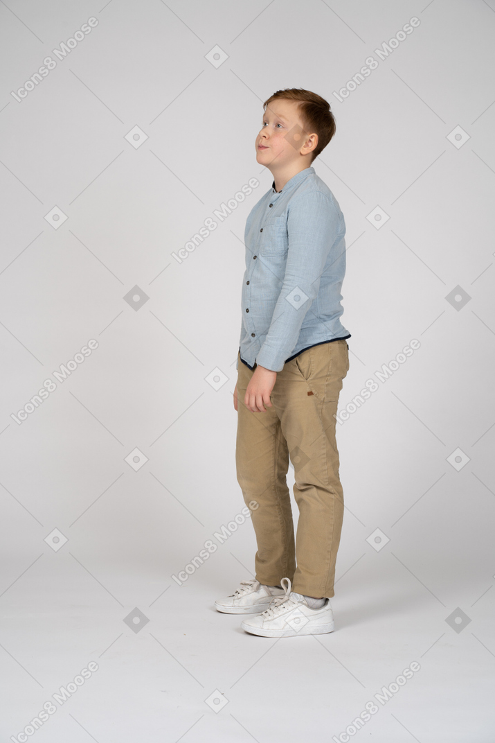 Vista lateral de un chico triste mirando hacia arriba