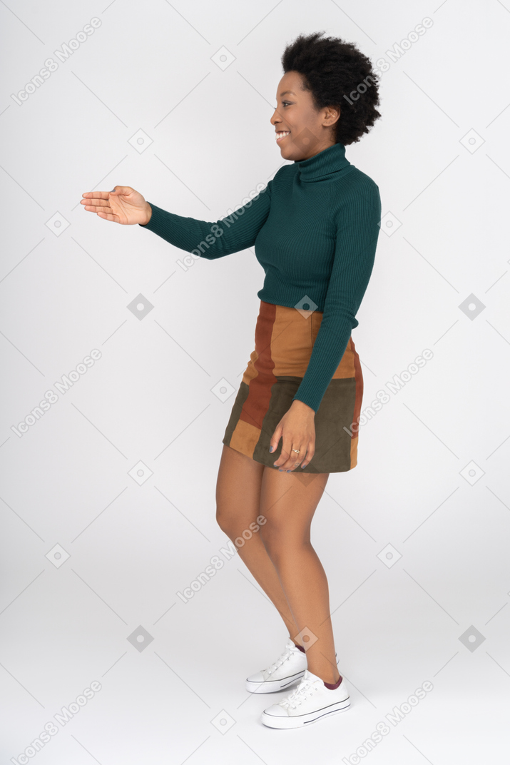 Smiling african girl standing with outstretched hand ready for handshake