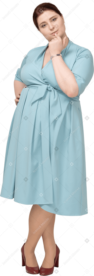 一个穿蓝色裙子的女人咬着手指的前视图