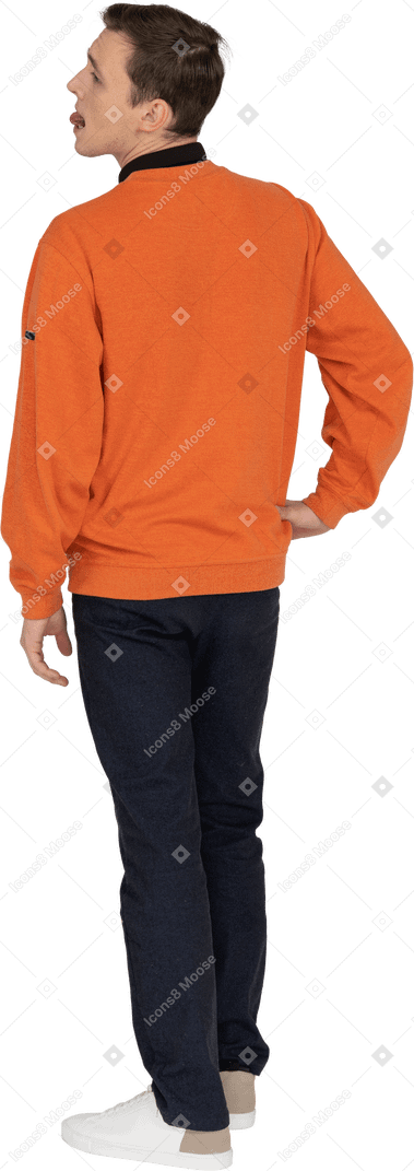 Young man in orange sweatshirt standing