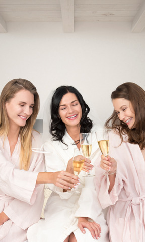 A group of women in robes holding champagne flutes
