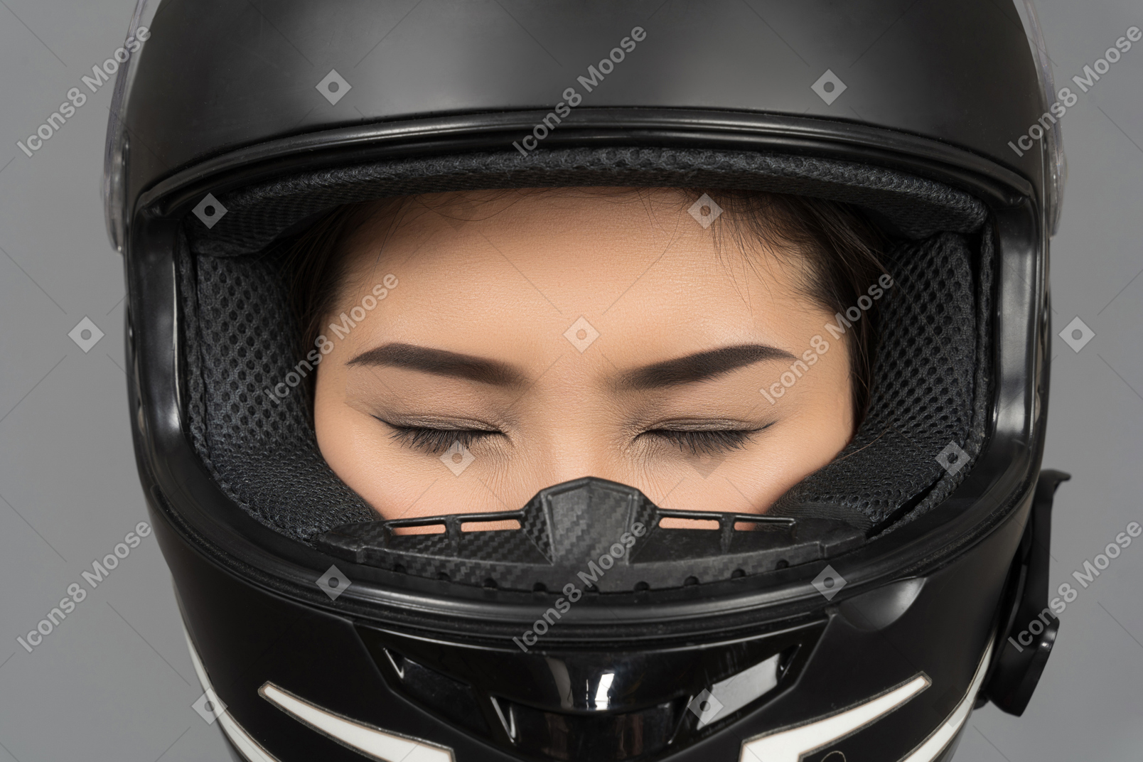 Uma mulher com os olhos fechados, usando um capacete preto