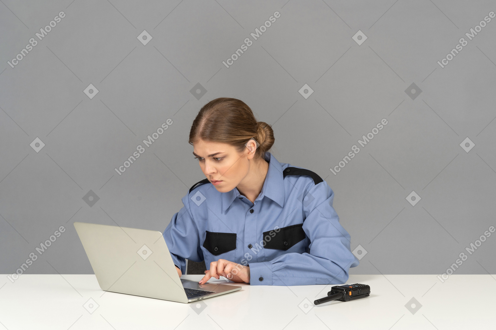 Um guarda de segurança feminino pensativo olhando para um laptop