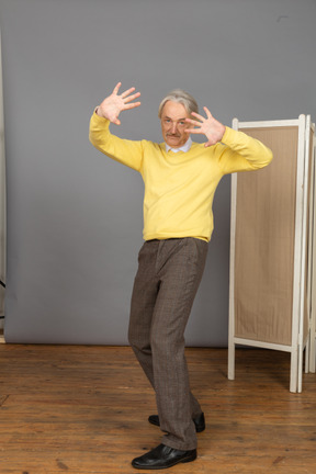 Three-quarter view of a dancing old man outspreading his fingers