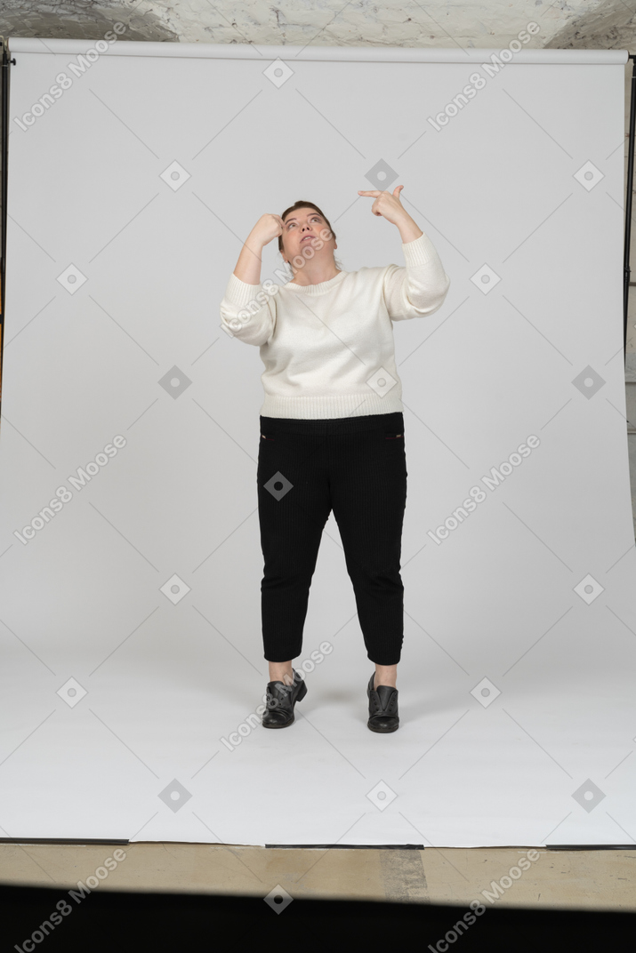 Front view of a plus size woman in casual clothes looking up