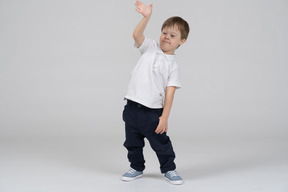 Vista frontal de um menino levantando a mão