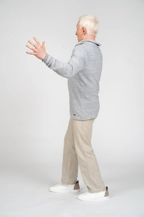 Vista lateral de un hombre de pie con el brazo doblado y los dedos extendidos