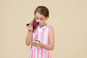 Cute little girl applying makeup