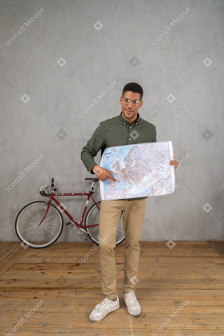 一名男子拿着并指着地图的正面图