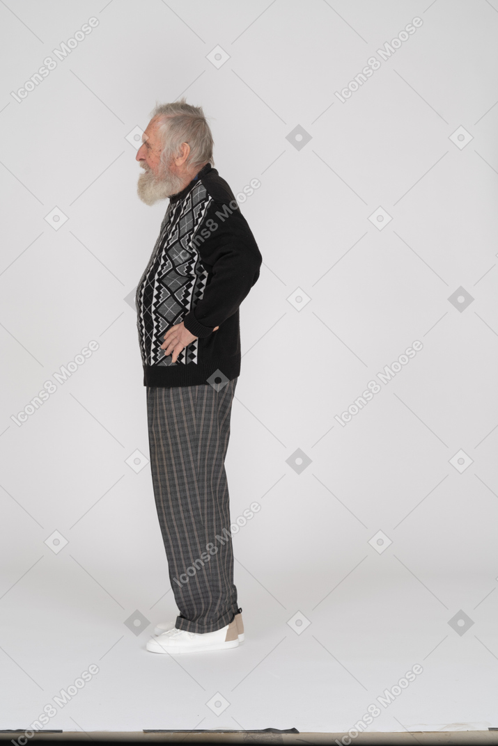 Side view of an elderly man with his hands on his hips