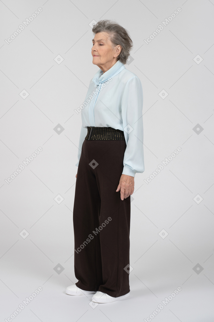 Вид в три четверти на пожилую женщину, стоящую на месте
