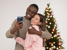 Feliz pareja interracial celebrando la navidad